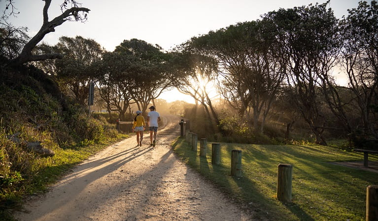 Walkers at sunset at Diamond Head campground, Crowdy Bay National Park. Photo: Rob Mulally/DPIE