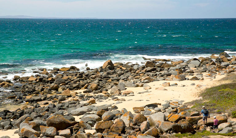 Two people walking among the rocks at Bingi Bingi Point, Eurobodalla National Park. Photo: David Finnegan &copy; OEH