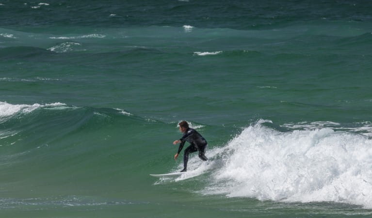 A surfer riding the waves at Bingi Bingi Point in Eurobodalla National Park. Photo: David Finnegan &copy; OEH