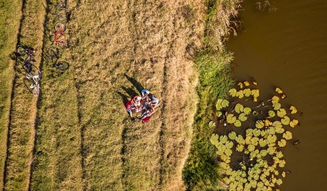 Aerial shot of friends picnicking on the banks of Woody Creek. Photo: John Spencer/OEH