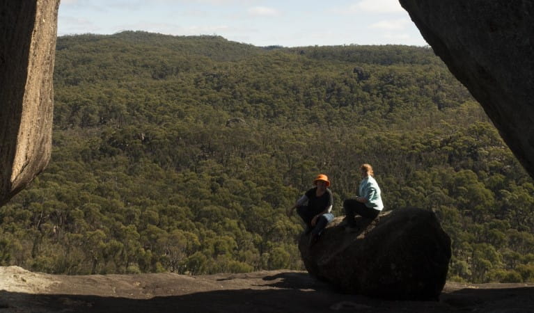 2 people sitting on a rock along Dandahra Crags walking track. Photo: Leah Pippos &copy; DPE