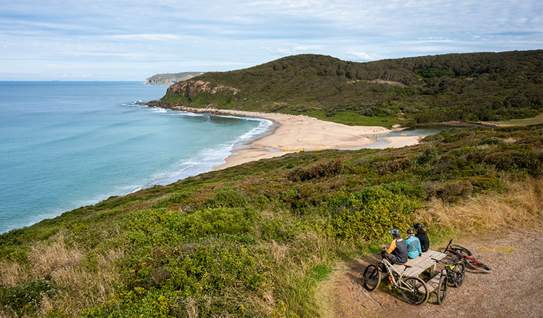 3 cyclists taking a break beside the ocean. Photo: John Spencer &copy; DPE