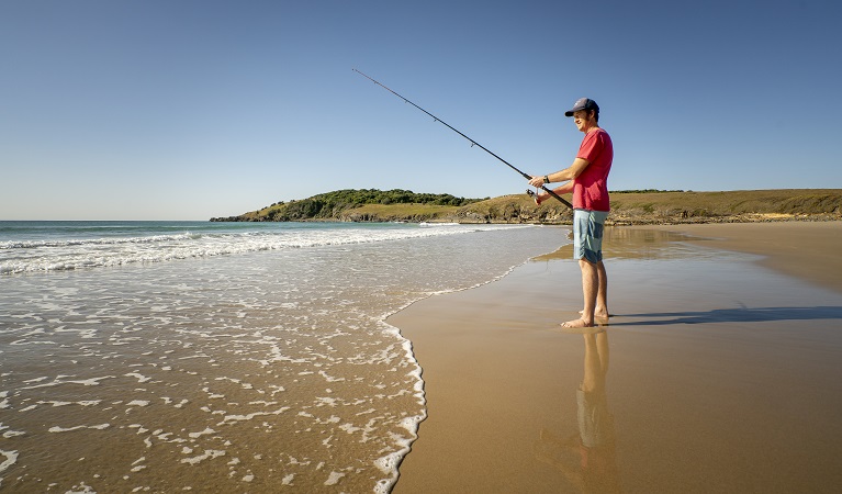 A man on Goolawah beach fishing nearby Racecourse campground, Goolawah National Park. Photo: John Spencer/OEH