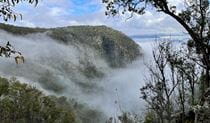 View of rugged mountain flank and valley shrouded in cloud. Photo &copy; Tina Sullivan