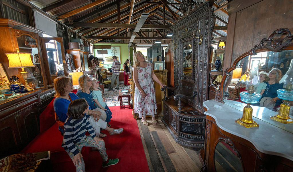 People admiring a large antique mirror inside Gold Rush Antiques at Hartley Historic Site. Credit: John Spencer &copy; DCCEEW