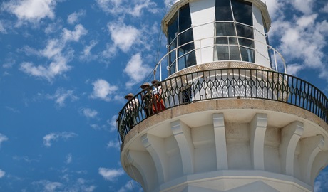 Visitors admire the view from the balcony at the top of Smoky Cape Lighthouse, Hat Head National Park. Photo: Louise Walpole/DCCEEW &copy; DCCEEW