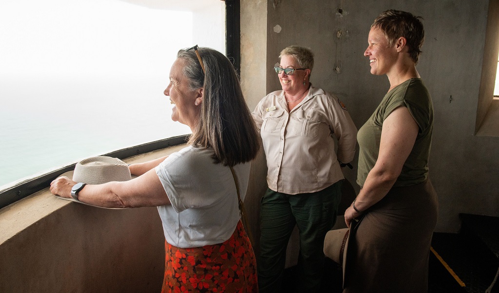 Visitors pause to enjoy the view from a curved lighthouse window, as they climb the lighthouse stairs with an NPWS guide, Smoky Cape Lighthouse, Hat Head National Park. Photo: Louise Walpole/DCCEEW &copy; DCCEEW