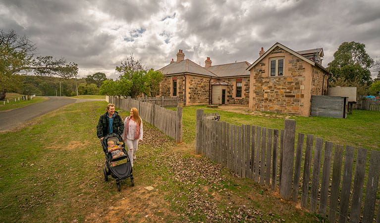 Family with baby walking past Post Office Residence and Stables in Hill End Historic Site. Photo: John Spencer/OEH