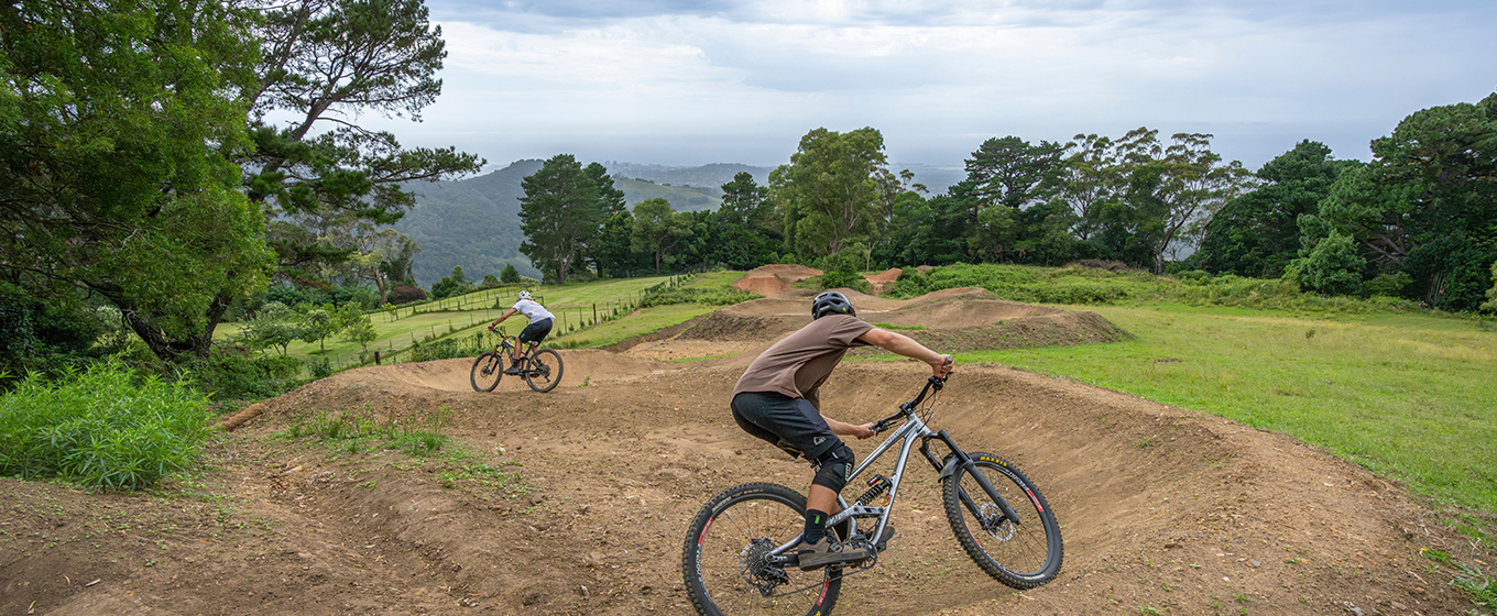 Mountain bike riders tackle the berms with views over the Illawarra to the ocean. Credit: John Spencer © DCCEEW
