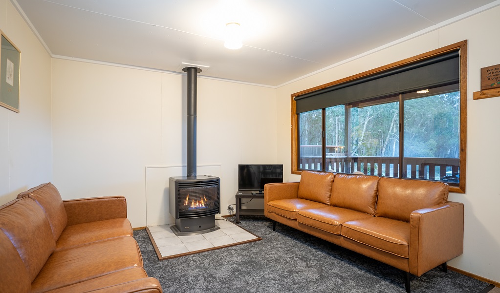 Dining room with log fire, Binda Bush Cabins, Jenolan Karst Conservation Reserve. Photo: Jenolan Caves &copy; DPE 