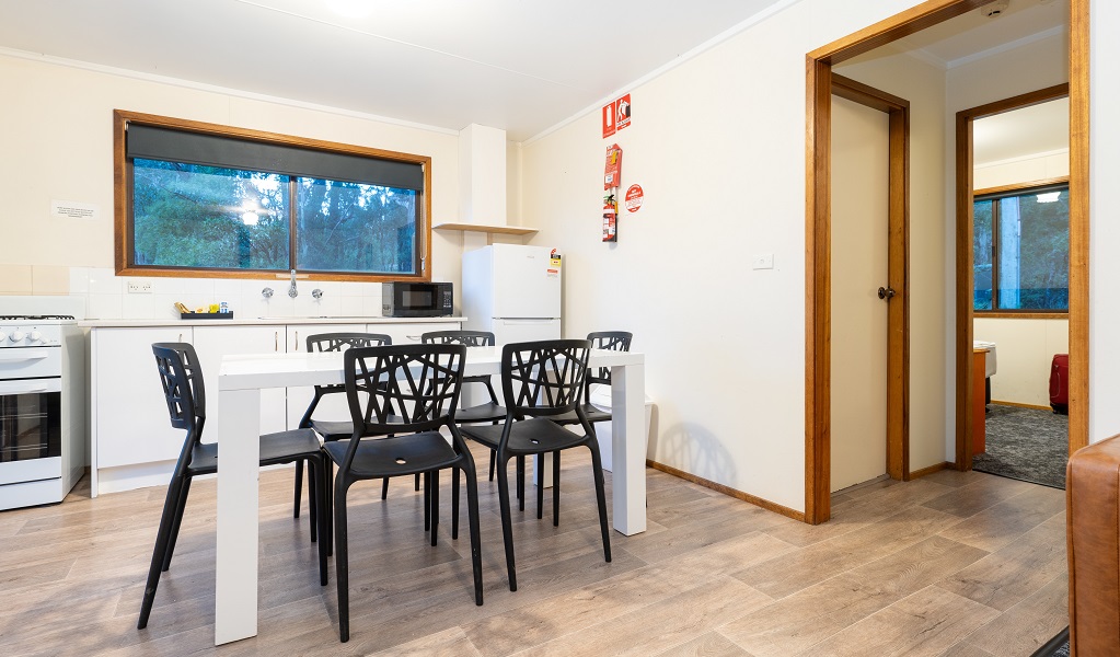 Kitchen and dining table, Binda Bush Cabins, Jenolan Karst Conservation Reserve. Photo: Jenolan Caves &copy; DPE 