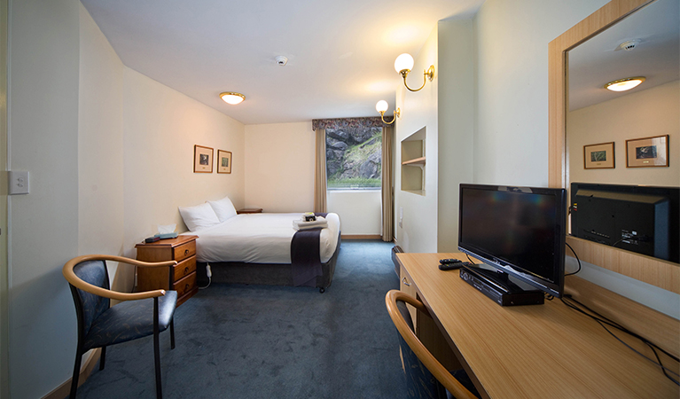Guestroom with bed, chairs and desk at Jenolan Mountain Lodge, Jenolan Karst Conservation Reserve. Photo: Keith Maxwell, A Shot Above Photography