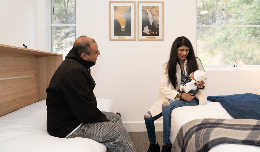 A couple relax with their baby in their room at Jenolan Mountain Lodge, Jenolan Karst Conservation Reserve. Photo: Jenolan Caves &copy; DPE 