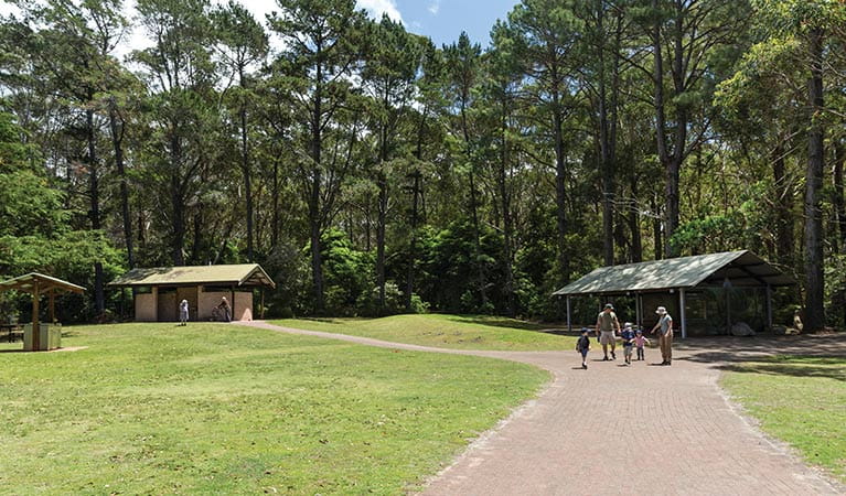 A family pass a picnic shelter at Greenfield Beach picnic area, Jervis Bay National Park. Photo: David Finnegan &copy; DPIE