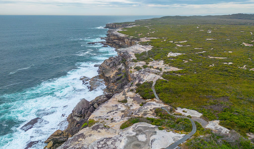 Aerial photo of the walking track from Cape Solander leading south to Cape Baily with coastal heathland and cliffs. Photo: John Spencer &copy; DPE