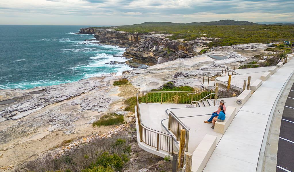 People looking out over the ocean from the whale watching platform at Cape Solander. Photo: John Spencer &copy; DPE