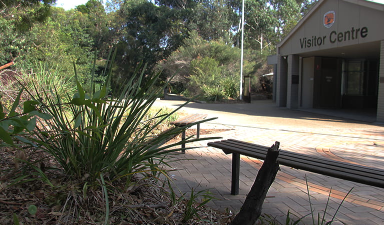 Visitor Centre building in bushland setting with a bench in the foreground. Photo: Natasha Webb/OEH