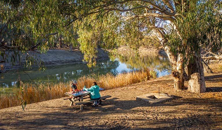 People having a picnic lunch on the river bank at campsite 22, Darling River campground. Photo: John Spencer/DPIE