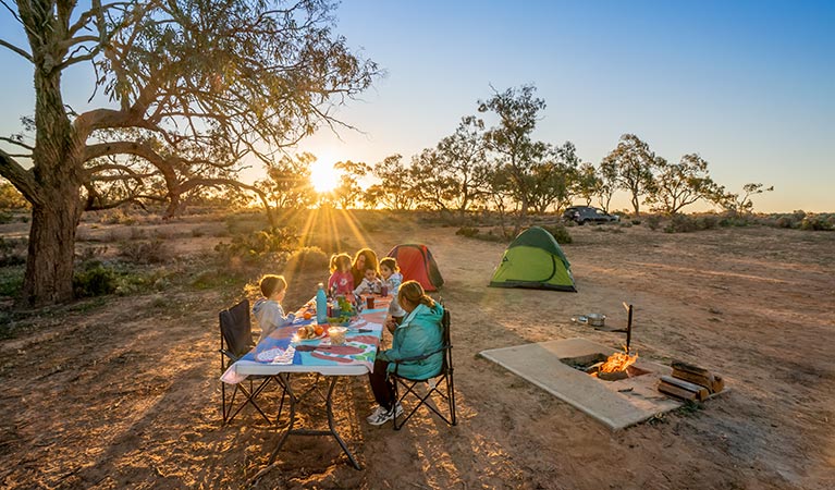 Family sitting down for a sunset meal at Emu Lake campground. Photo: John Spencer/DPIE