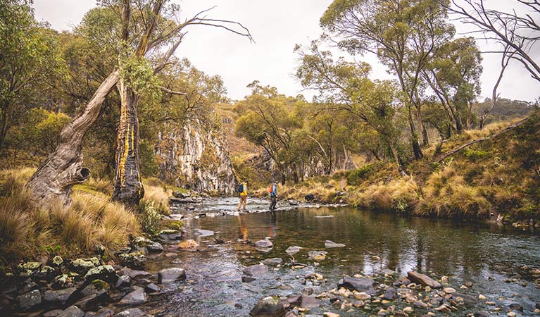 Two men cross the river on Clarke Gorge walking track in northern Kosciuszko National Park. Photo &copy; Robert Mulally