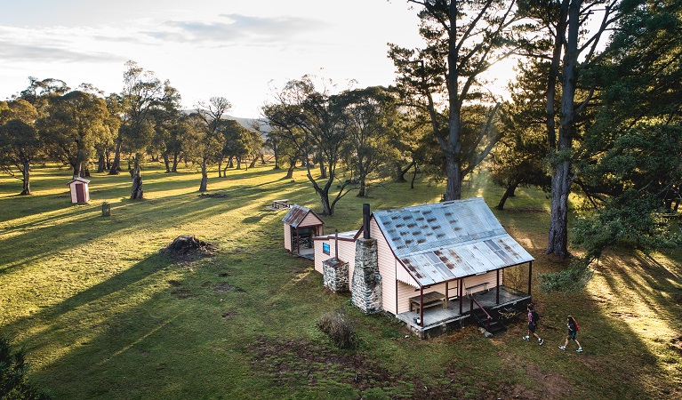 A bird's eye view of a couple walking to Daffodil Cottage, Kosciuszko National Park. Photo: Rob Mulally/DPIE