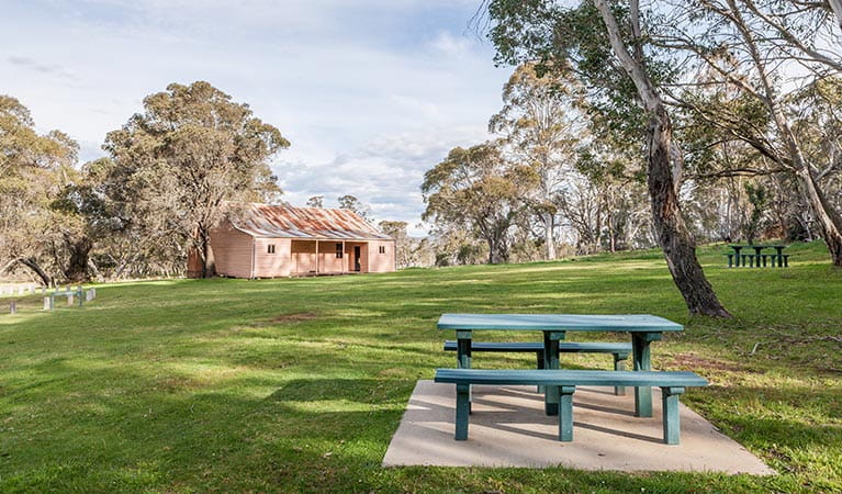 A picnic table and grassy lawn in front of Long Plain Hut, Kosciuszko National Park. Photo: Murray Vanderveer