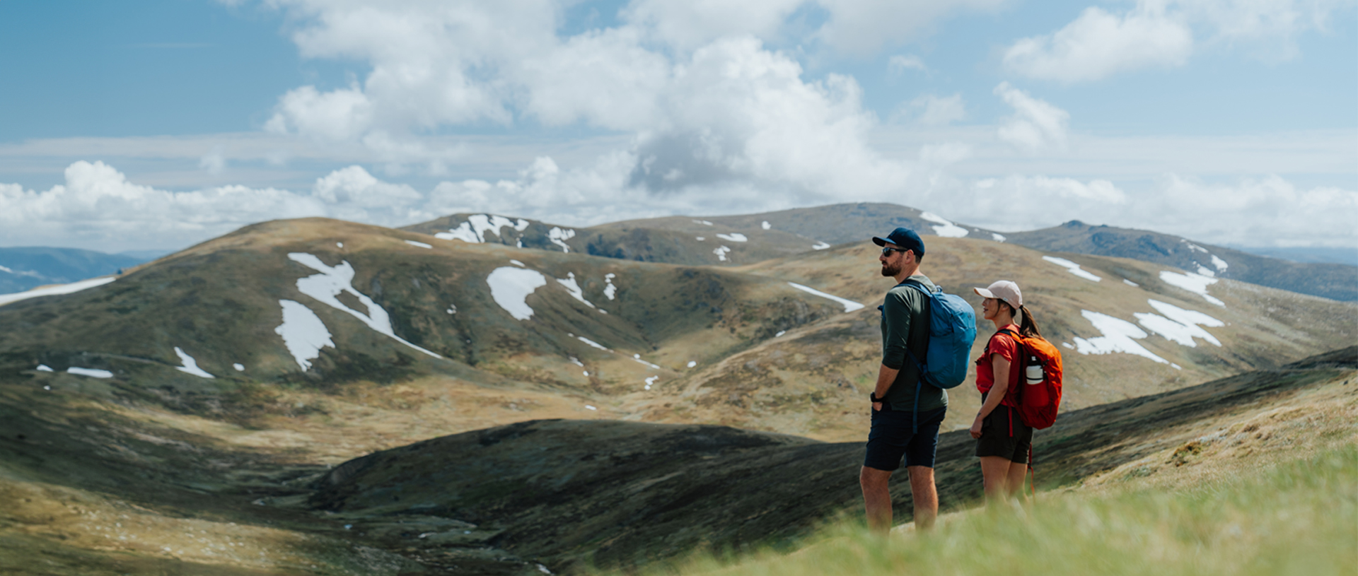 2 hikers admiring snow capped Main Range mountain views on day 2 of Snowies Alpine Walk. Credit: Remy Brand / DCCEEW © Caravel Content