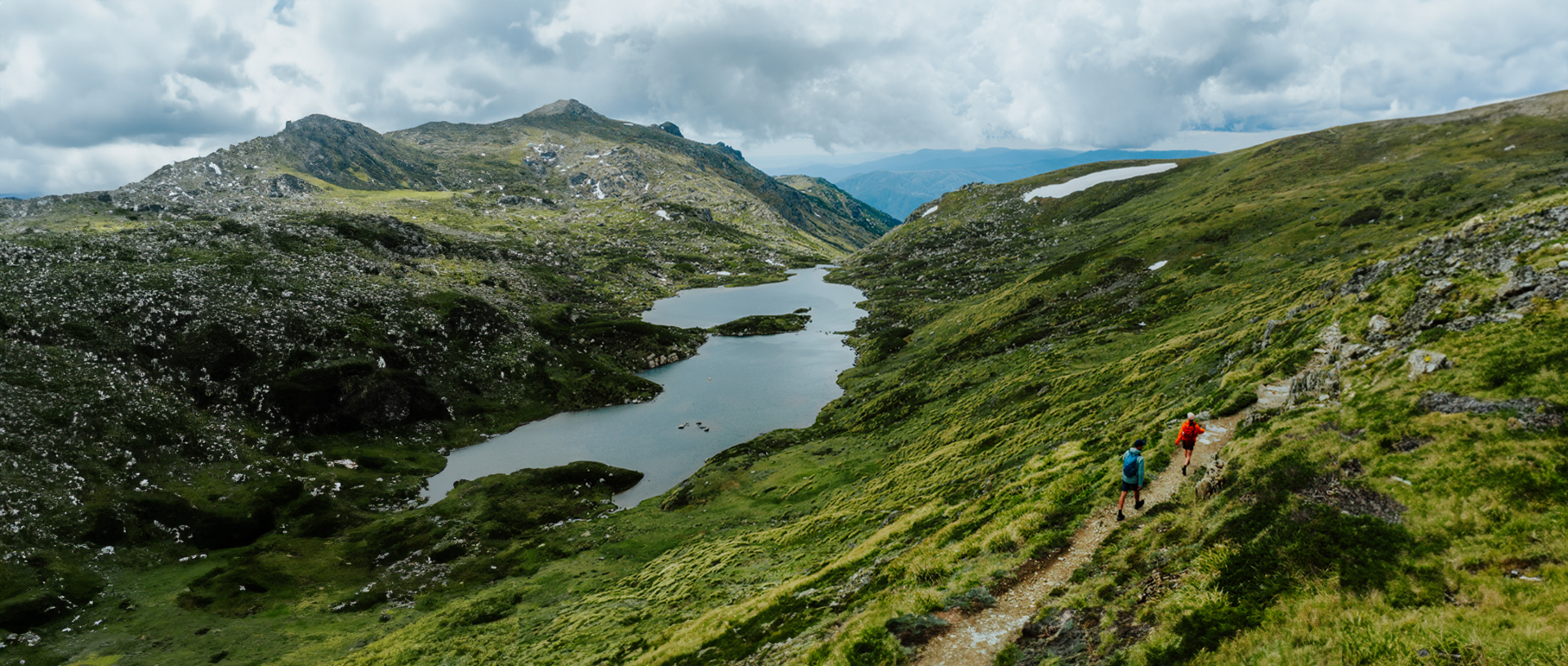 An aerial view of 2 hikers on Snowies Alpine Walk in the Thredbo-Perisher area with Blue Lake in the background. Credit: Daniel Parsons / DCCEEW © Caravel Content