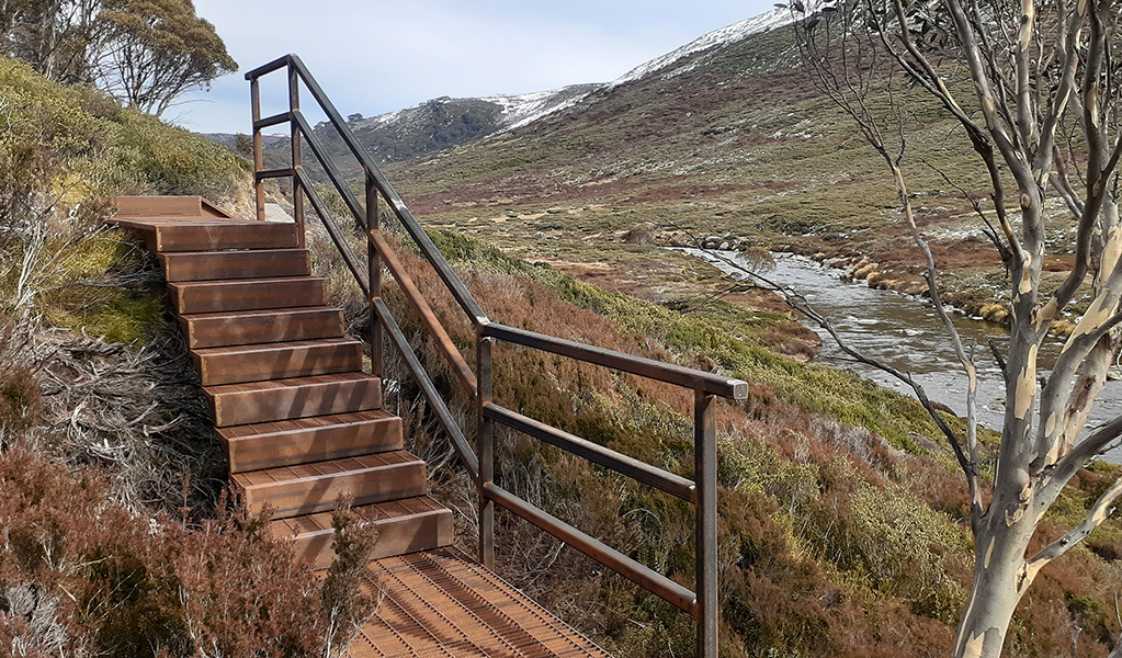 A set of steps climbs through river valley, part of Charlotte Pass to Illawong walk in Kosciuszko National Park. Photo credit: Aleksandr Cahill &copy; DPIE