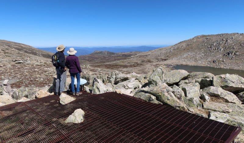 A couple takes in the view from Cootapatamba lookout in Kosciuszko National Park. Photo: Luke McLachlan &copy; DPIE