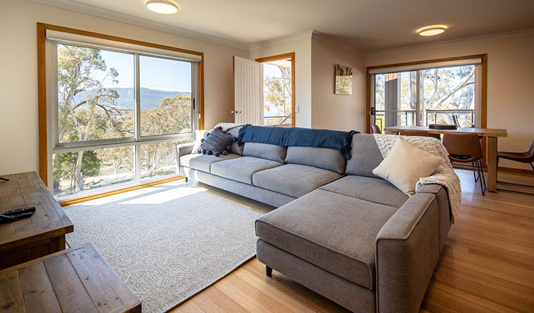 Open-plan lounge and dining area with central fireplace in Creel Bay cottages. Photo &copy; Murray Vanderveer