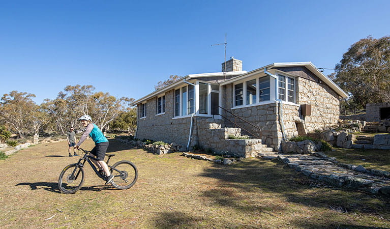 The exterior of Creel Bay cottages with a guest riding a bike on the lawn. Photo &copy; Murray Vanderveer