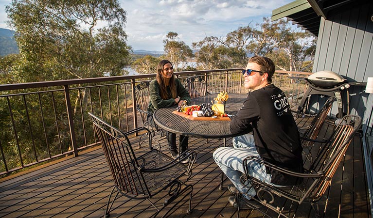 A couple relax on the balcony at Creel Lodge, Kosciuszko National Park. Photo: Boen Ferguson/OEH.