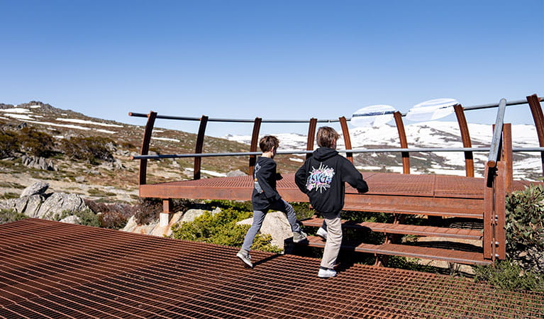 2 young boys step onto a lookout on Mount Stilwell walk, looking out over Kosciuszko National Park. Photo &copy; Johnny Mellowes