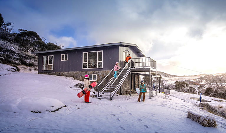 A family in the snow outside Numbananga Lodge, Kosciuszko National Park. Photo: Murray Vanderveer/OEH