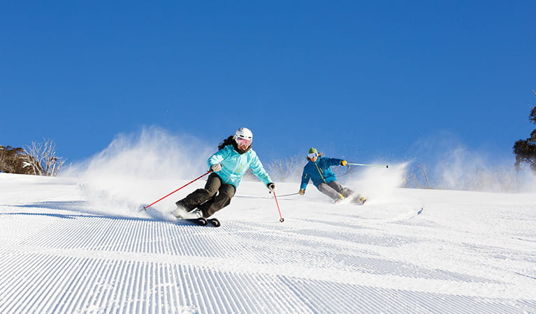 Two skiers on freshly groomed slopes at Thredbo, Kosciuszko National Park. Photo: Thredbo Resort