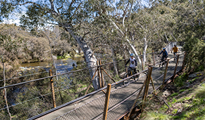 A family of cyclists cross Gaden Bridge on the Thredbo Valley track. Photo: Boen Ferguson © Boen Ferguson