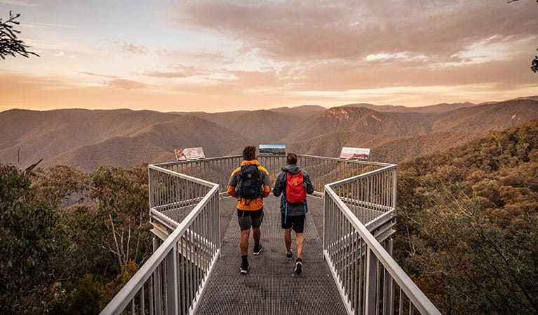 2 men walk to Black Perry lookout at sunrise, Tumut area, Kosciuszko National Park. Photo: Robert Mulally/OEH.