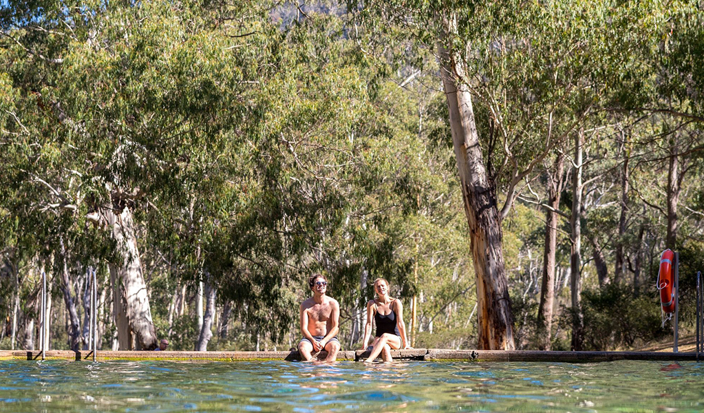 A couple sit by the thermal pool, Yarrangobilly area in Kosciuszko National Park. Credit: Boen Ferguson/DCCEEW &copy; Boen Ferguson