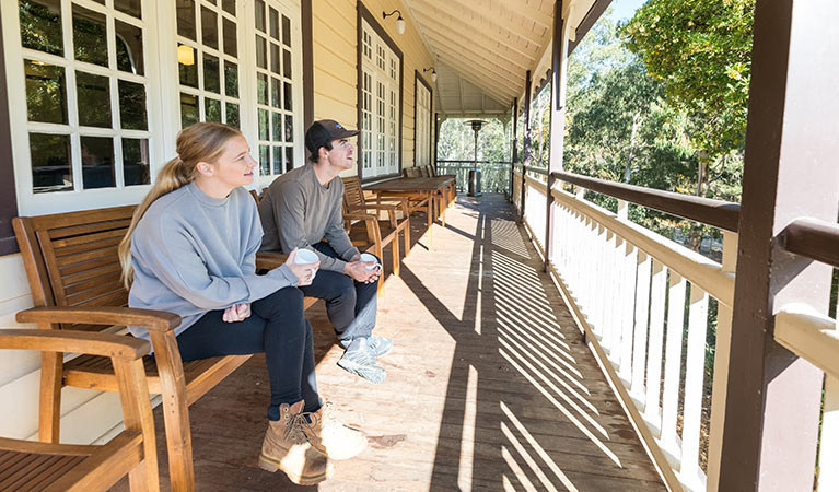 A couple on the balcony at Yarrangobilly Caves House 1917 section, Kosciuszko National Park. Photo: Boen Ferguson/OEH