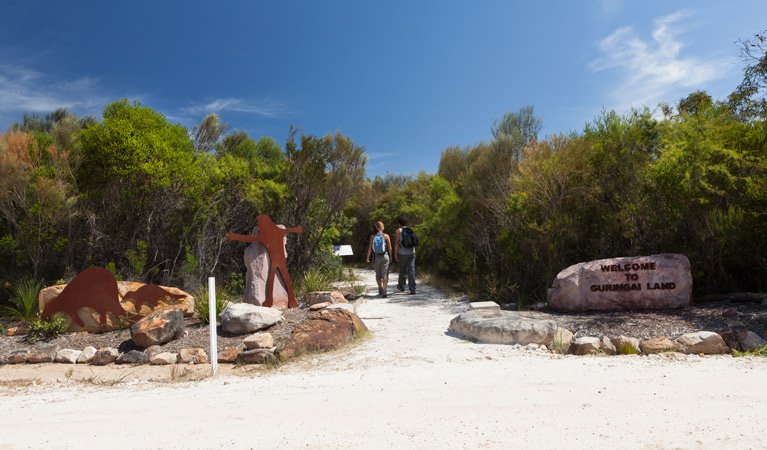 Two people walking through The Basin Aboriginal art site in Ku-ring-gai Chase National Park. Photo: David Finnegan &copy; OEH