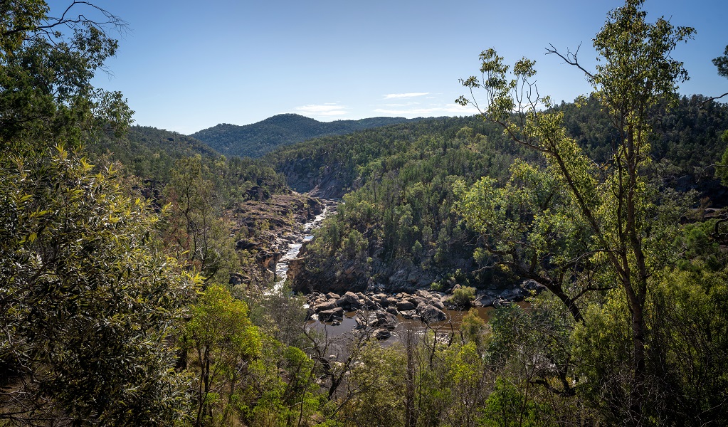 The view over the river, which is bordered by rocks and thick trees, with mountains in the distance, Junction walk, Kwiambal National Park. Photo: DPE &copy; DPE