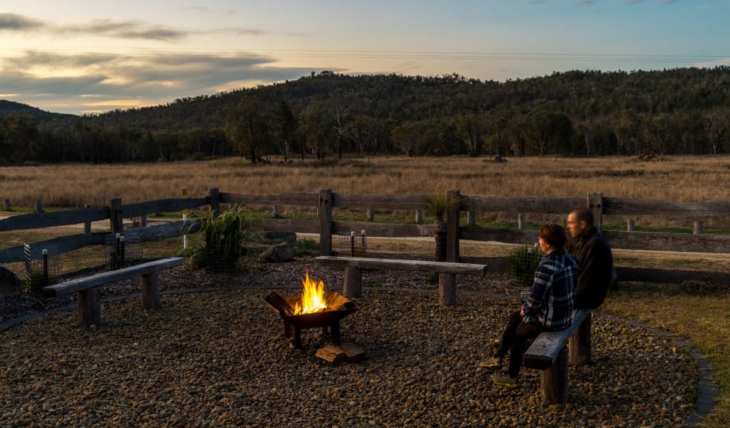 2 people sitting on a bench by the firepit at Lavender Vale Homestead. Photo &copy; DPE