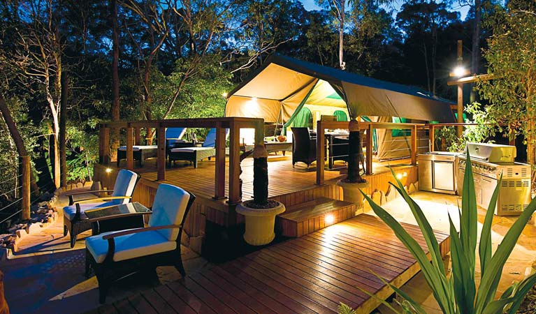 Views of a luxurious tent at Lane Cove Holiday Park - Tandara, lit up at night. Photo: OEH