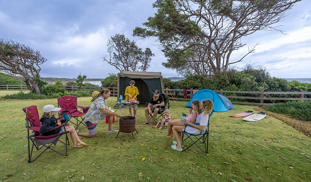 A family camping on a grassy site at Point Plomer campground. Credit: John Spencer &copy; DCCEEW