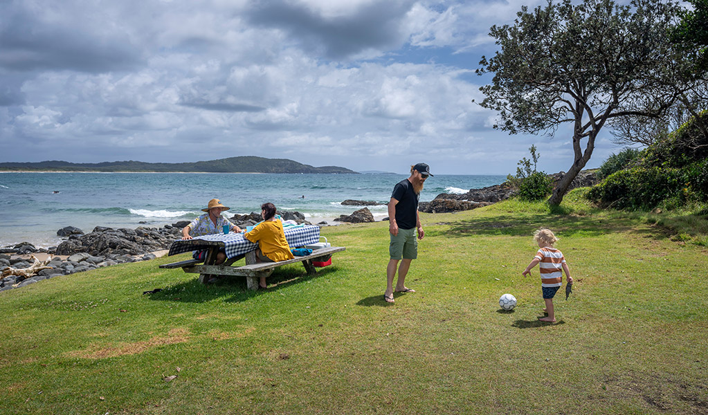 A fisherman cleaning his fish on a bench nearby the beach at Point Plomer campground, Limeburners Creek National Park. Photo: John Spencer/OEH