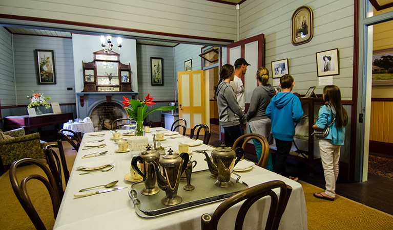 A group of people look at photos on the wall of the dining room in Roto House, nearby Macquarie Nature Reserve. Photo: John Spencer/NSW Government