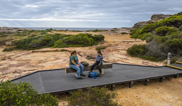 Walkers taking a rest on a bench, Western Escarpment walking track. Photo: John Spencer &copy; DPE