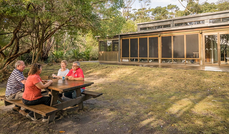 Visitors at a picnic table outside Myer House in Mimosa Rocks National Park. Photo: OEH/John Spencer
