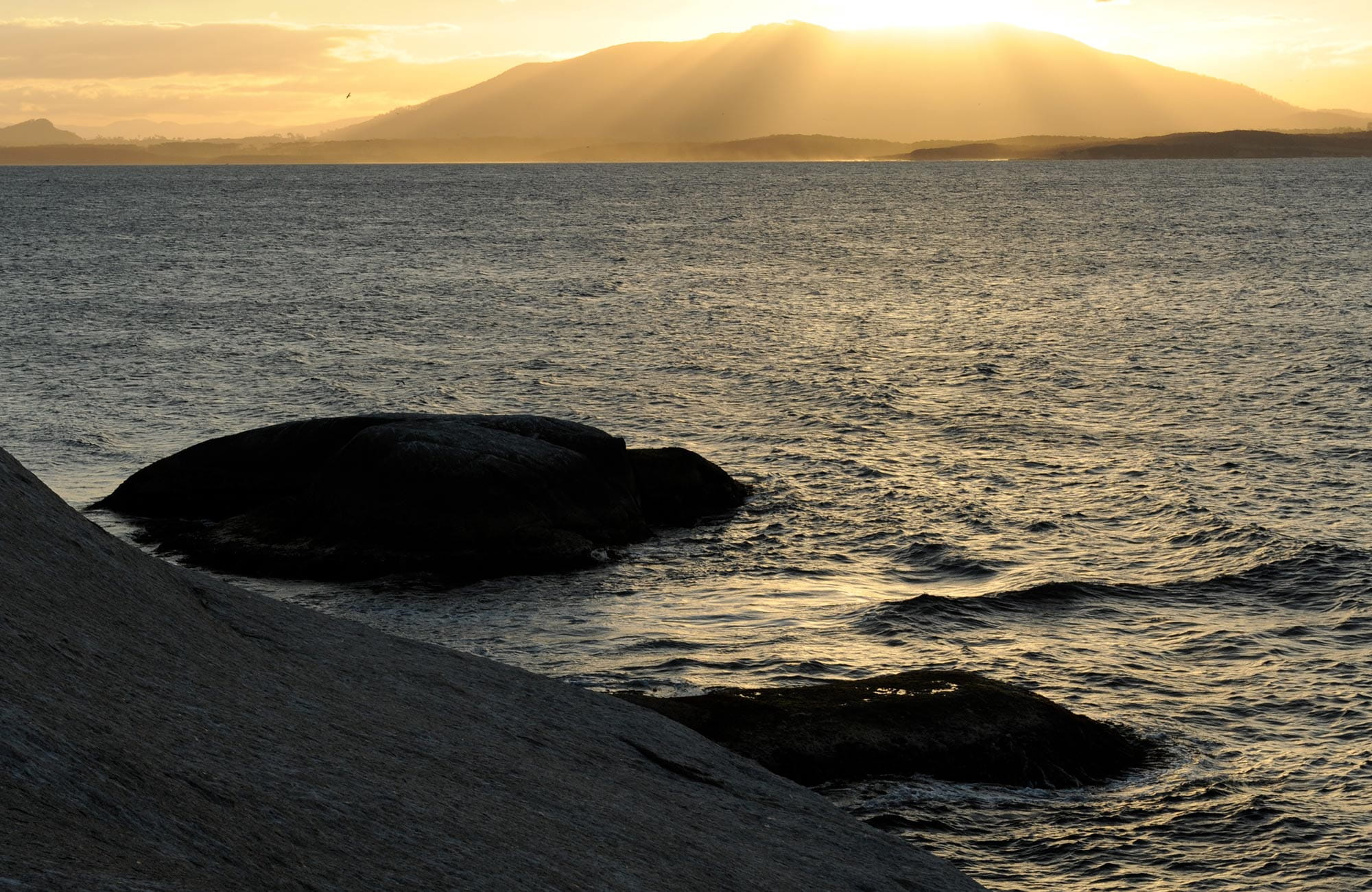 View from Montague Island across the sea as the sun sets behind Gulaga, near Narooma. Photo: Stuart Cohen/OEH